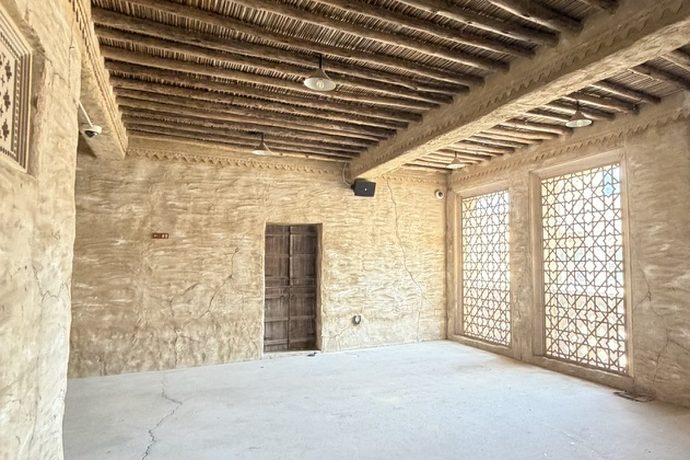 Stone room with a wooden beam ceiling and latticed screens