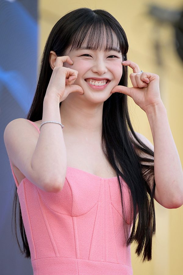 Someone beaming, framing their face with their hands